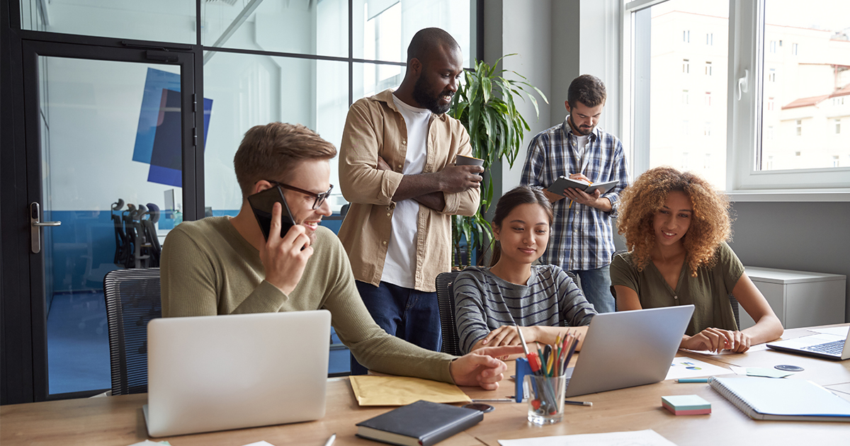 employees sitting around desk together