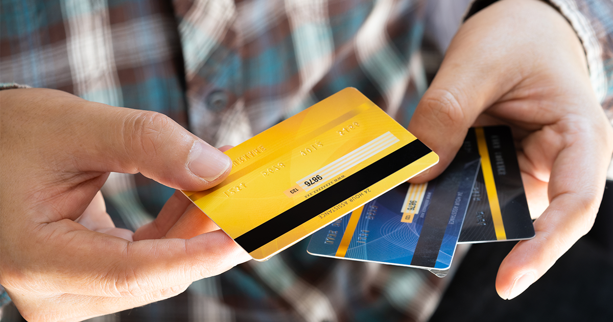person holding 3 credit cards