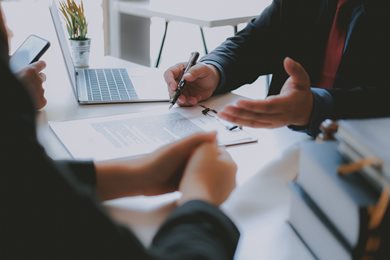 person reviewing document with others at desk