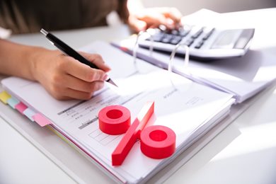 person calculating totals with pen and paper