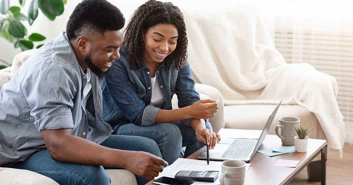 couple looking at laptop and documents