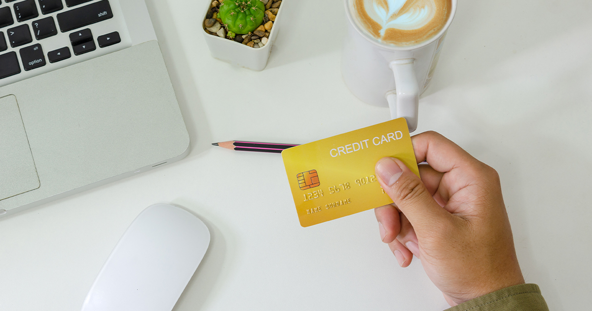 person holding credit card on desk