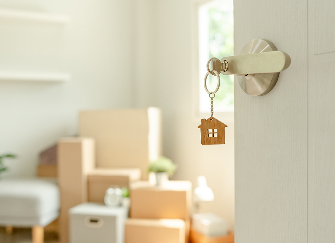 key in door with house keychain hanging