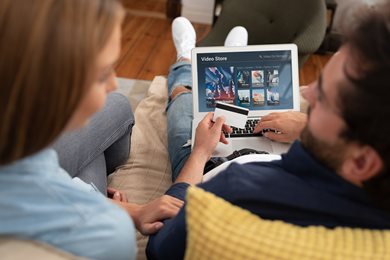 young couple ordering a video streaming service on a laptop