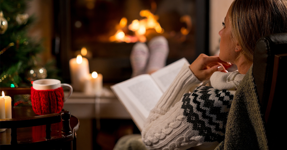 person reading in front of fireplace