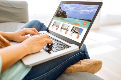 person looking at travel website on a laptop