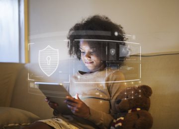 child on tablet with cybersecurity symbols over photo