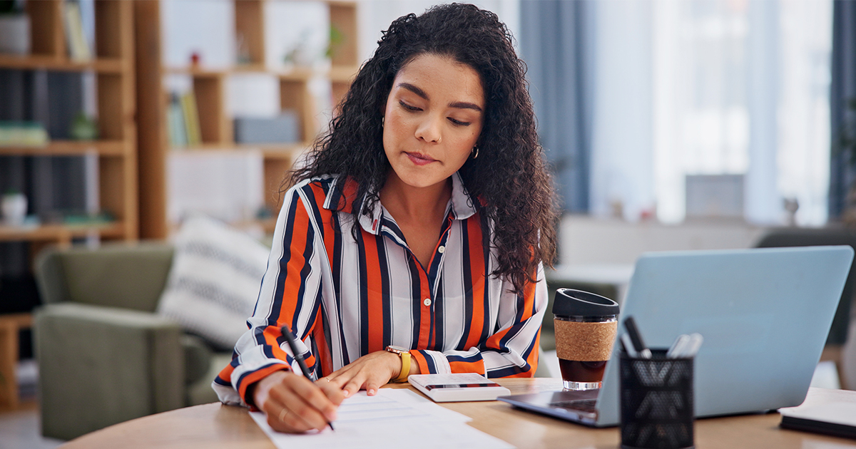 woman at desk writing on paper