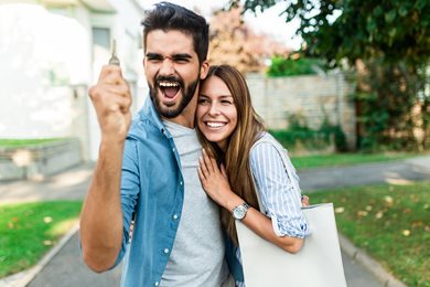 excited couple holding a home key