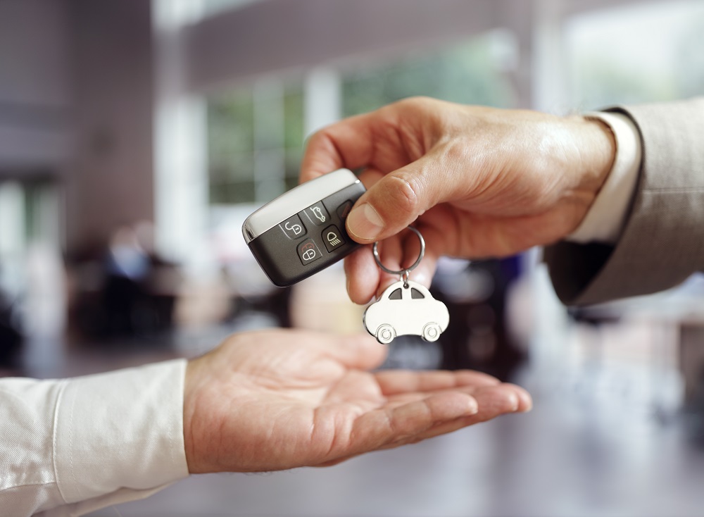 person handing another keys with car keychain