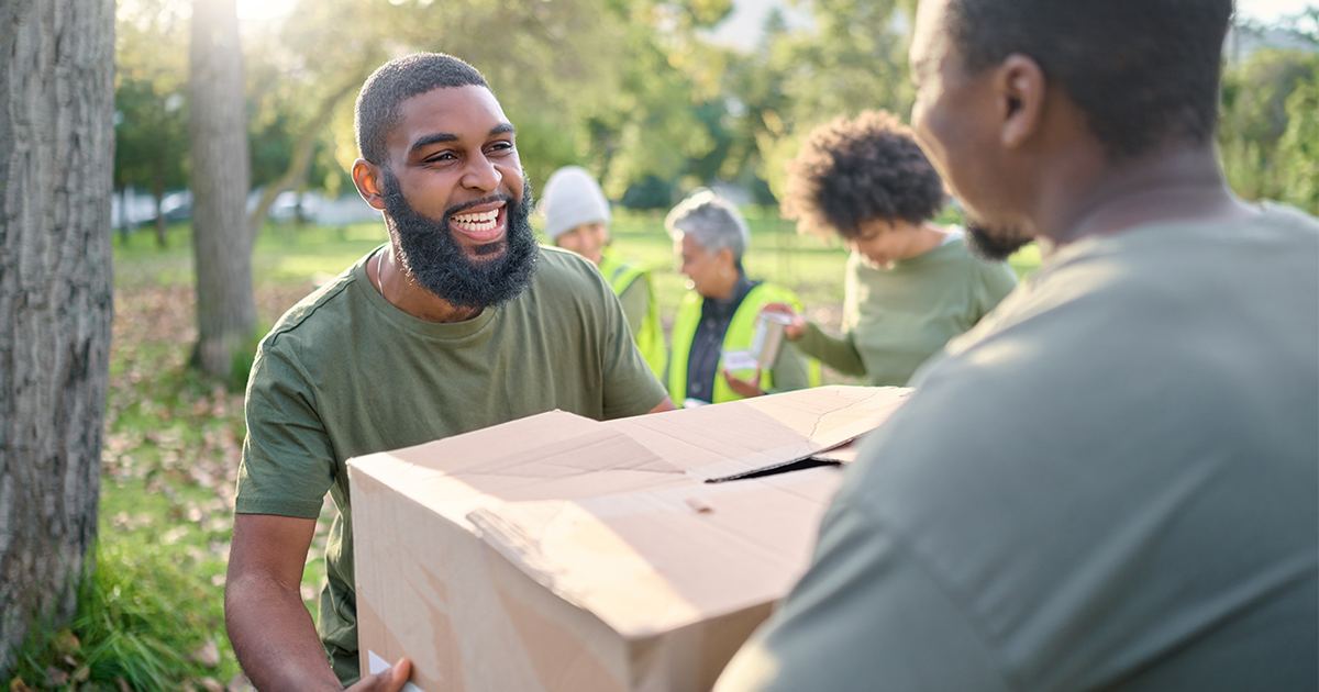 man handing box to another man