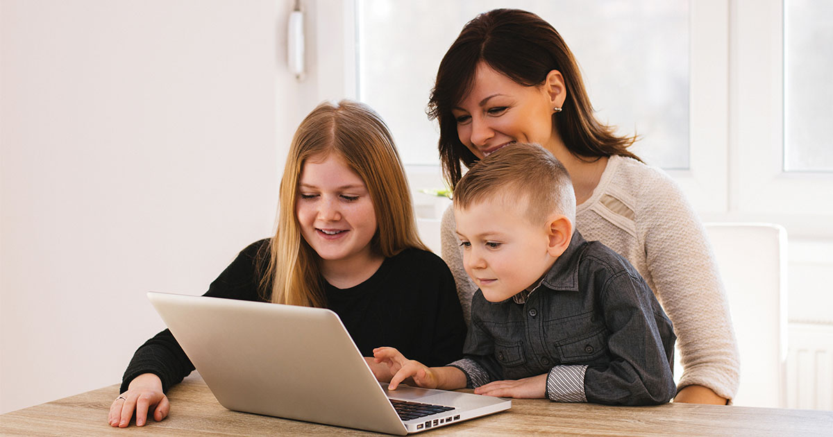 parent looking at computer with two children