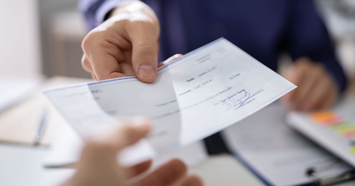 person handing paper check