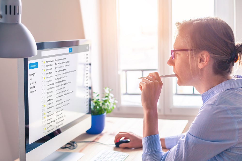 Woman scrolling through email on computer