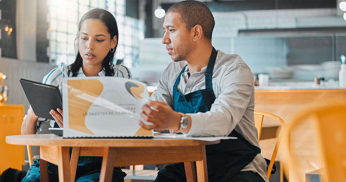 two people reviewing business documents