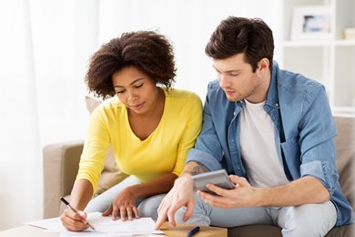 a couple reviewing bills and calculating totals