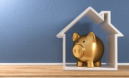 golden piggy bank inside of a home-shaped cutout