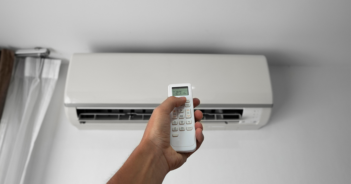 person controlling heat pump with remote