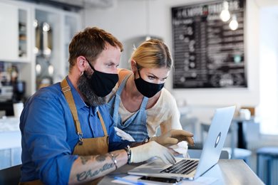 Male and female small businesses owners working on laptop 