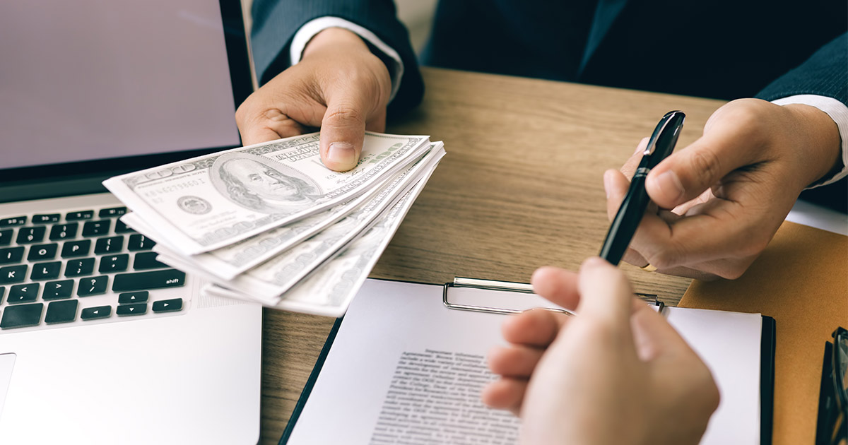 person handing over cash and pen