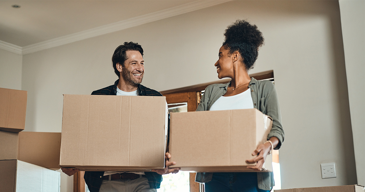 couple moving boxes into home