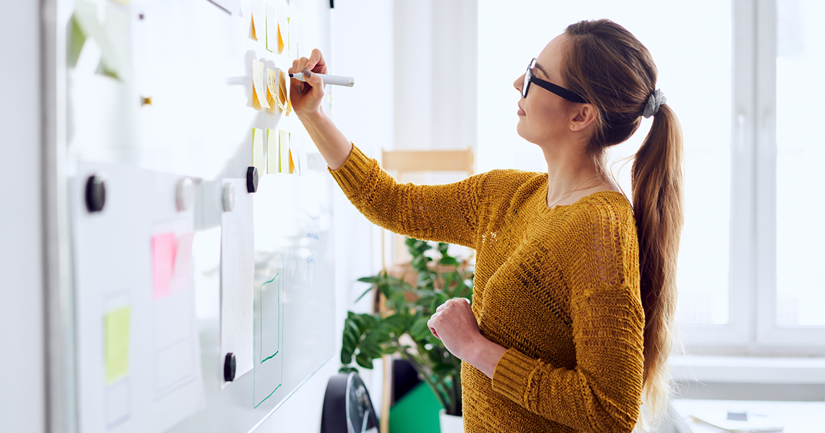 woman writing on white-board